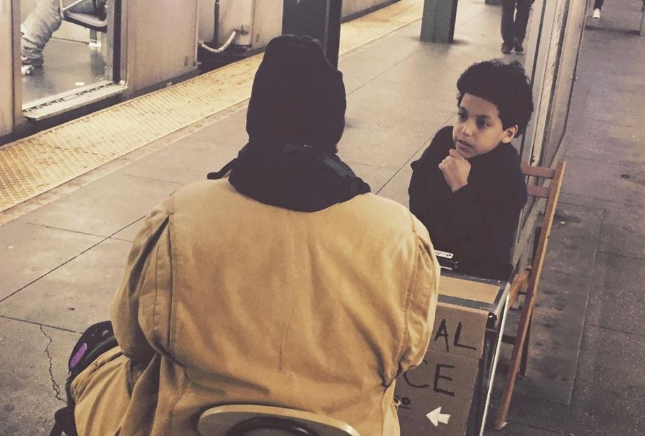 Photo of 11-year old giving advice in subway station to a passenger